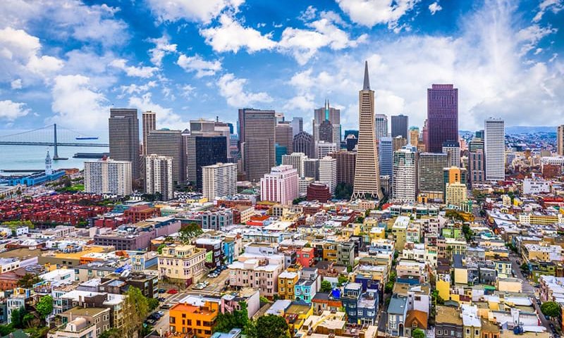 A panoramic view of the San Francisco skyline at sunset, with the silhouette of iconic skyscrapers outlined against a vibrant orange sky. This image visually represents the dynamic and innovative leadership environment in San Francisco, reflecting the city's role as a hub for executive development and tech innovation.